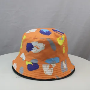 Vue détaillée du chapeau bob orange à imprimé abstrait coloré, montrant le motif du tissu.