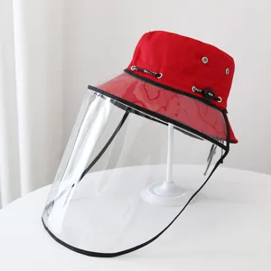 Dettaglio ravvicinato dello schermo facciale protettivo trasparente e cappello rosso.