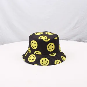 Black bucket hat with yellow smiley face print, wide brim sun protection outdoor cap.