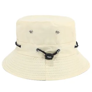 Beige bucket hat with adjustable black drawstring and metal eyelets for outdoor sun protection.
