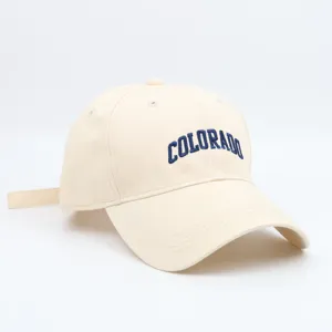 Close-up detail of a beige baseball cap with navy blue embroidered Colorado lettering.