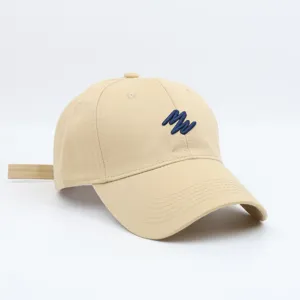Detailed view of the beige baseball cap with blue embroidery, featuring adjustable strap.