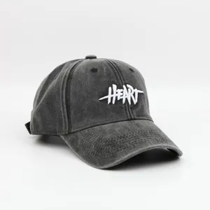 Close-up detail of the washed vintage baseball cap with white heart embroidery design.