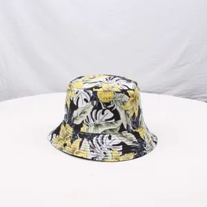 Detail view of a floral print bucket hat with black white and yellow tropical leaves pattern.