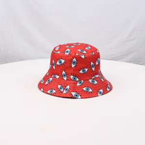 Detailed close-up of a red bucket hat featuring a trendy blue evil eye print pattern.