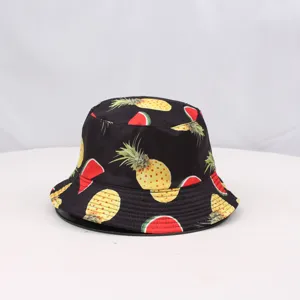 Gros plan détaillé du chapeau bob noir avec motif de fruits tropicaux, ananas et pastèque.
