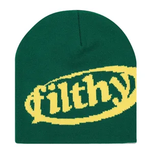 Detailansicht einer grünen Winter-Strickmütze mit stylischem gelben Filthy-Textmuster.