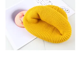 Detailed close-up view of a vibrant yellow winter knitted beanie cap, soft ribbed texture.