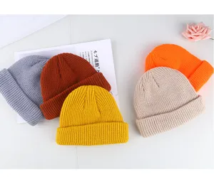 Solid color knit beanie docker cap detail view showing multiple vibrant winter hat colors available.