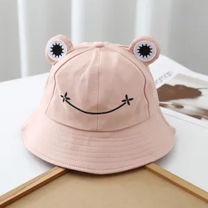 Cute frog bucket hat detail shot, pink cotton fabric with lovely embroidered eyes and smiley face.