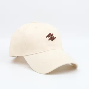 Beige baseball cap detail view, featuring brown embroidered letters and clean stitching.