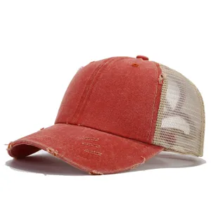 Dettaglio di un berretto da baseball in mesh rosso slavato con parte anteriore strutturata.