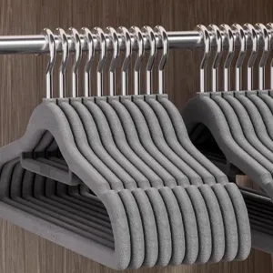 Close-up detail of grey flocked clothes hangers featuring metal hooks inside wardrobe.