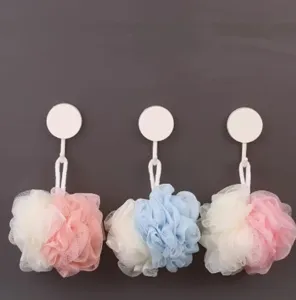 Vista detallada de esponjas de baño de malla coloridas colgadas en ganchos para el hogar