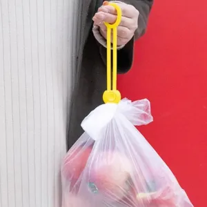Nahaufnahme des gelben Plastikbeutel Verschlussclips und tragbaren Griffgurts im Gebrauch.
