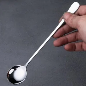 Detailaufnahme eines edelstahl Löffels mit langem Griff, ideal zum Umrühren von Kaffee und Honig.