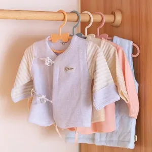 Cute plastic children hangers with bow detail, perfect for baby clothes organization in closet.