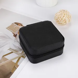 Portable black travel jewelry box with zipper closure for rings, earrings and small accessories.