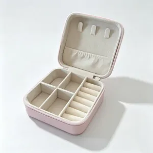 Detailed view of the pink portable travel jewelry box featuring velvet ring rolls and compartments.