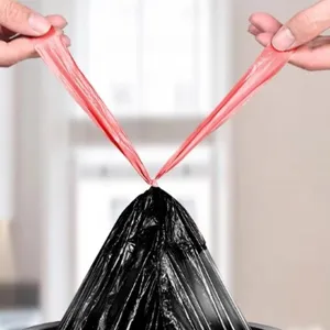 Müllbeutel Detailansicht mit Kordelzug, roten Griffen und schwarzem Kunststoff Material.