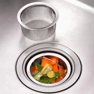 Edelstahl Küchen Spülbecken Siebkorb Detail mit Essensreste Filtration und Griff.