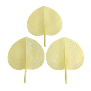Primo piano dettagliato di ventagli in foglia di palma di plastica gialla con texture.