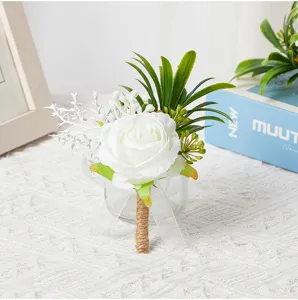 Artificial white rose boutonniere with burlap handle and green leaves for wedding party.