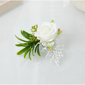 Detailed view of white artificial rose boutonniere with green leaves for wedding party prom suit.