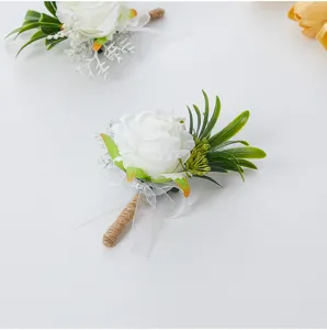 Detail shot of white artificial rose boutonniere, featuring elegant jute twine and chiffon bow.