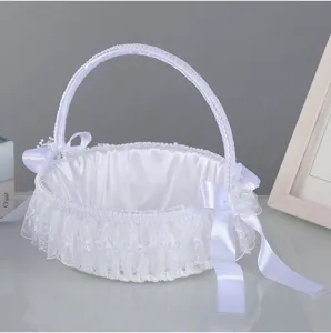 White wedding flower basket detail, featuring delicate lace trim and elegant satin bows.