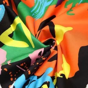 Primo piano dettagliato del tessuto camouflage graffiti colorato che mostra la trama.