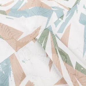 Close-up fabric detail of tropical leaf printed men's Hawaiian shirt showing soft texture.