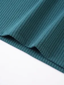 Dark teal ribbed knit tank top fabric detail, showing fine texture and neat stitching.