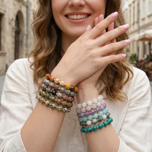 Chic stacked gemstone bracelets featuring multi-color faceted beads and vintage spotted stones.
