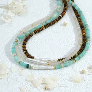 Gros plan d'un collier de perles superposé fait main avec œil-de-tigre et perles baroques.