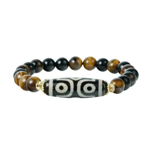 Closeup of a Tibetan style gemstone bracelet with tiger eye beads and a distinctive dzi bead.