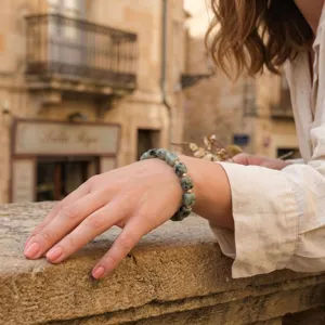 Close-up detail shot of irregular square green stone beaded bracelet with metallic accents.