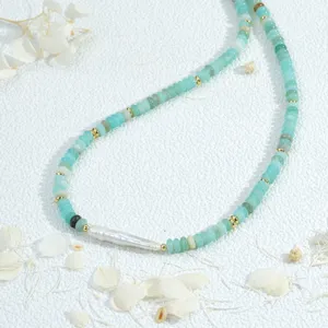 Vue détaillée de collier de perles plates vertes fait main avec intercalaires dorés et perle.