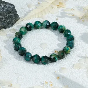 Detail van de gefacetteerde groene tijgeroog edelsteen armband met diepe kleurtinten.