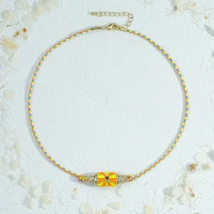 Colorful woven cord necklace with a hexagonal prism pendant and adjustable gold chain.
