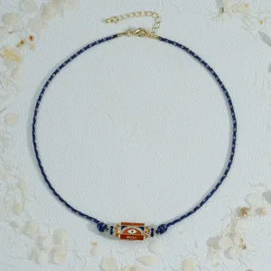 Handmade braided evil eye prism pendant necklace detail view with adjustable gold chain.