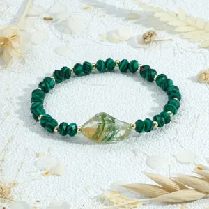 Close-up detail van groene kristal kralen stretch armband met onregelmatige glazen hanger.