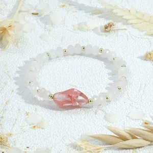 Gedetailleerde close-up van de onregelmatige roze kristallen kralenarmband met gouden spacers.