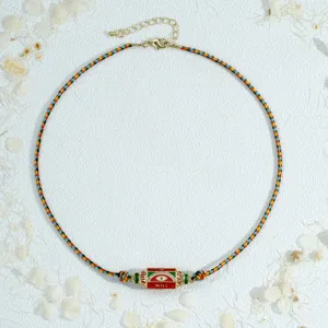 Detail view of the colorful woven evil eye necklace pendant, featuring a unique hexagonal prism.
