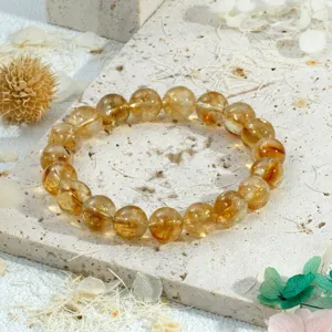Detailopname van sprankelende gele kristallen kralen armband op gestructureerde steen.