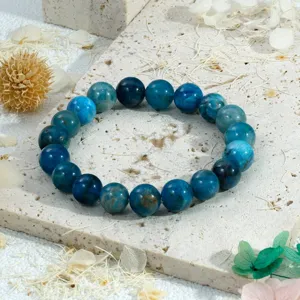 Detailopname van de blauwe kristallen kralen armband op een natuurlijke stenen achtergrond.
