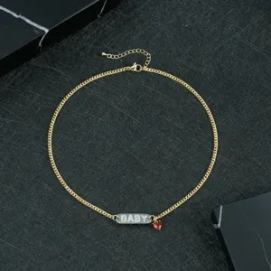 Gold-tone chain necklace featuring a rhinestone paved BABY letter tag and a cute red heart charm.
