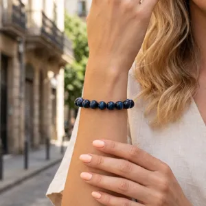 Blauwe tijgeroog edelsteen kralenarmband, detailopname aan de pols, vintage sieraden.