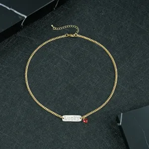 Gold-tone chain necklace featuring a 'Lucky' plaque and a red heart pendant for chic style.