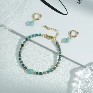 Elegante juego de pulsera y pendientes de cuentas azules con detalles de metal dorado.